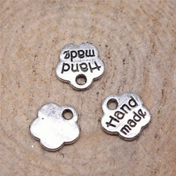 HARDWARE ACCESSORY: Flower shape "handmade" METAL Tags: Approx 8mm diameter: Set of 20 in nickel silver colour