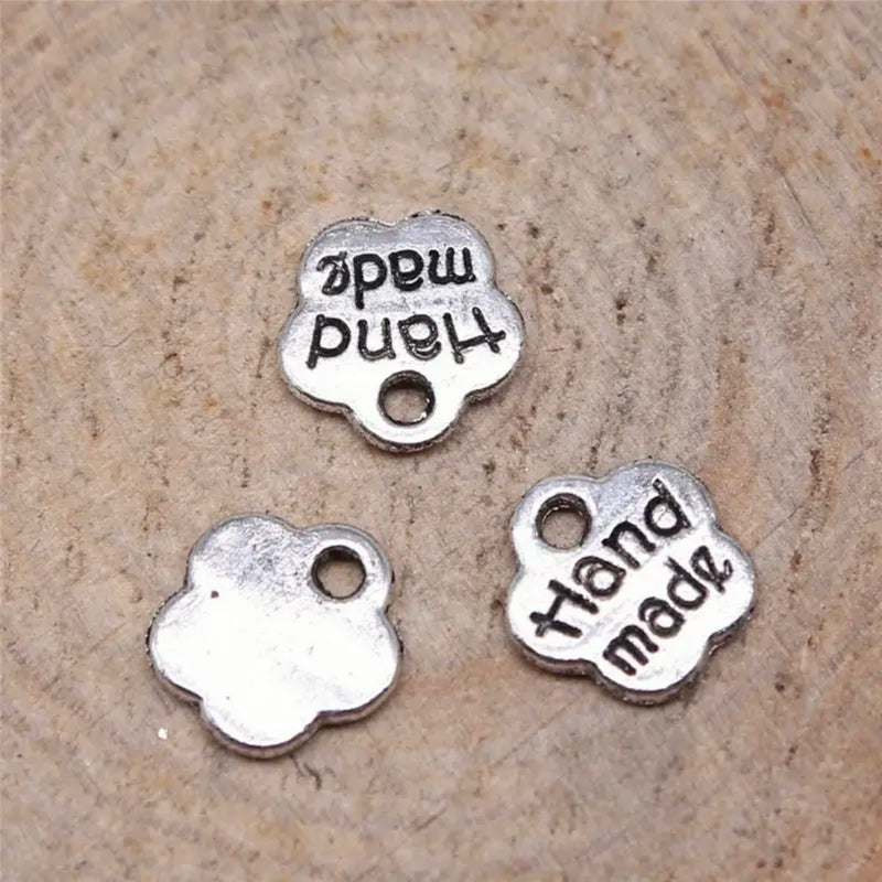 HARDWARE ACCESSORY: Flower shape "handmade" METAL Tags: Approx 8mm diameter: Set of 20 in nickel silver colour